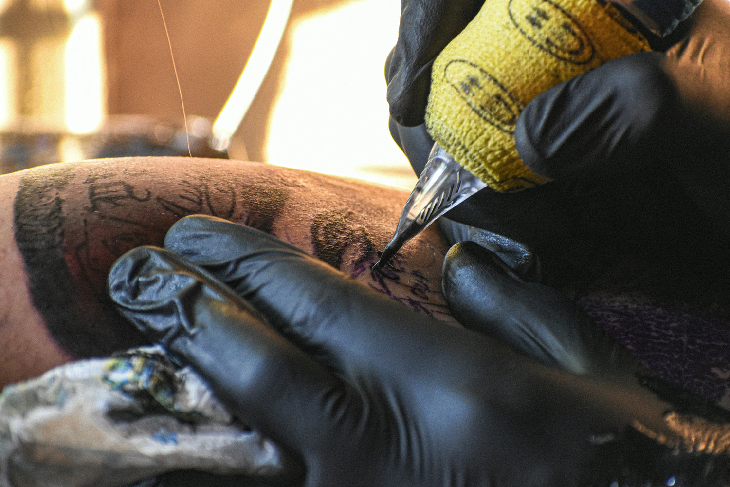 Tattoo needle close up tattooing skin using tattoo ink