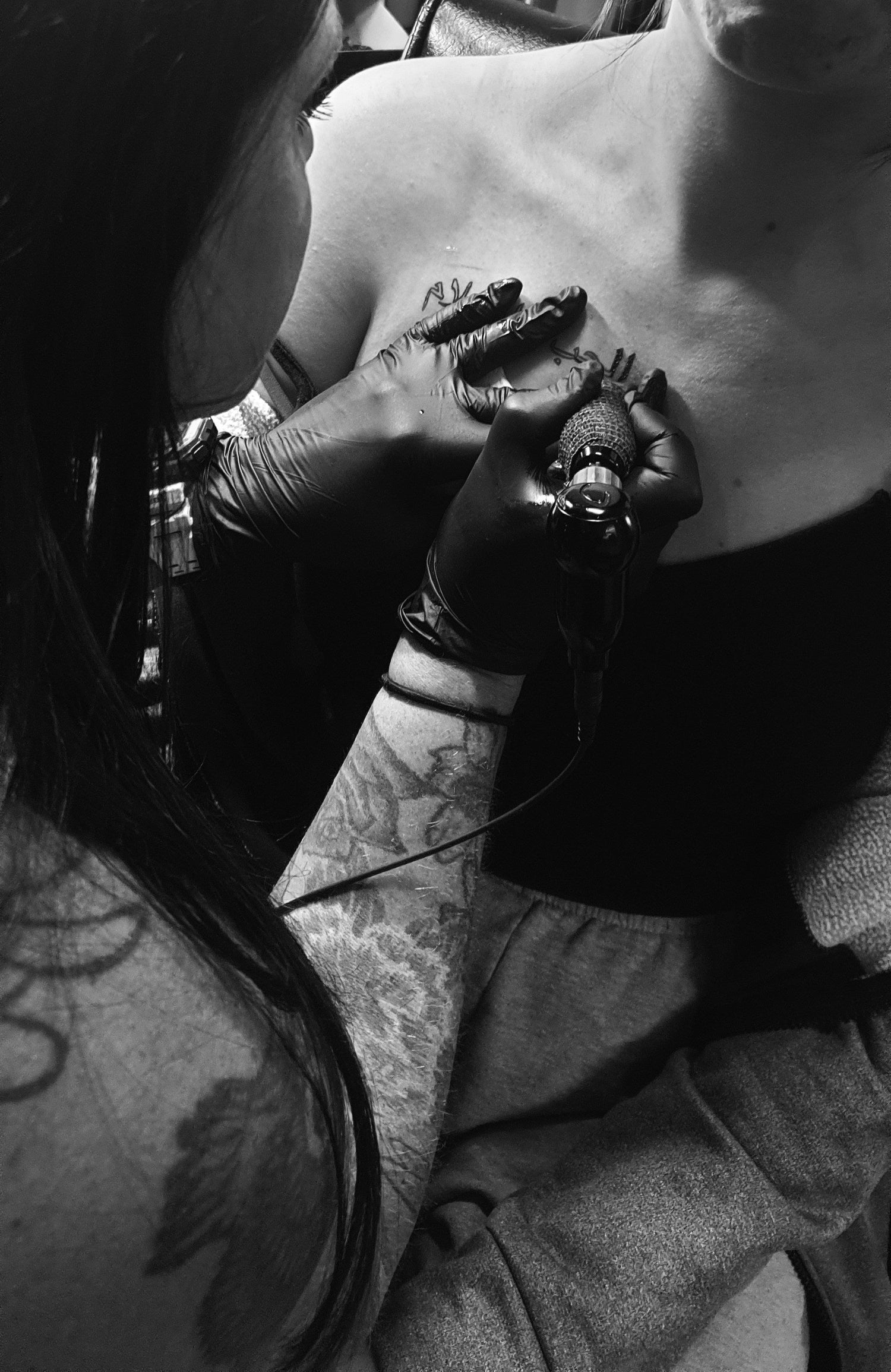 tattoo artist tattooing a chest with tattoo ink 